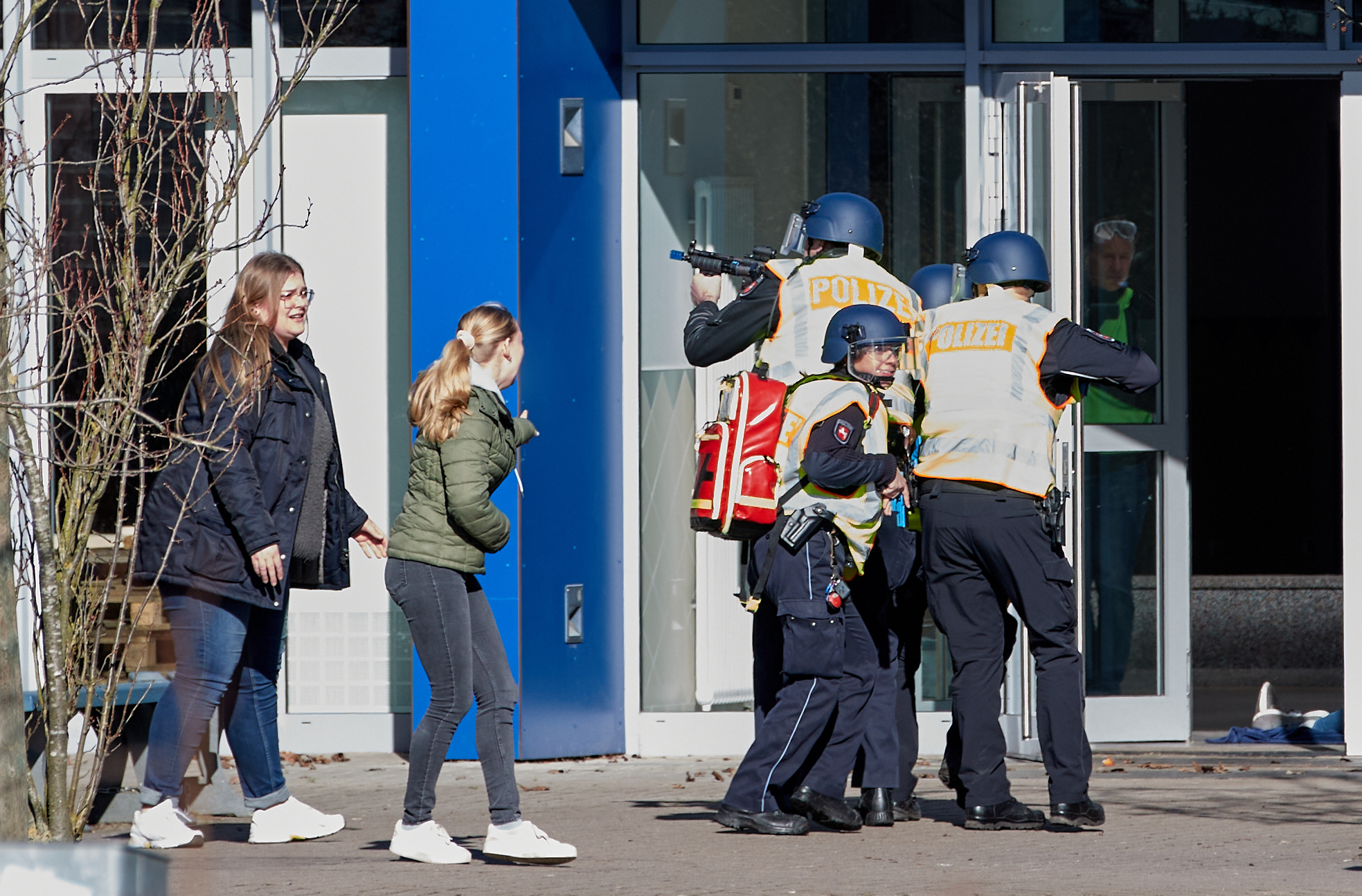 Polizist:innen stehen mit Maschinenpistolen vor einer Schule in Winsen. Am Sonntag wurde dort für den Ernstfall geübt.
