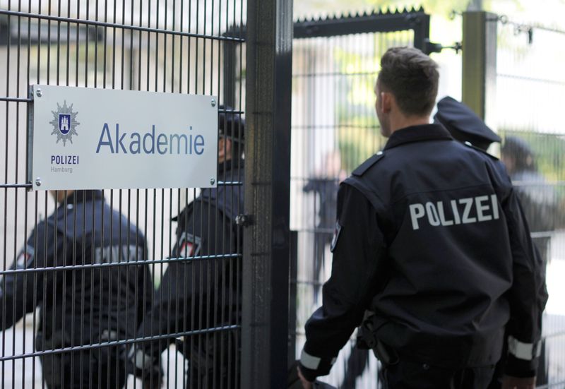 Polizeischüler gehen druch ein Tor der Akademie der Polizei Hamburg.