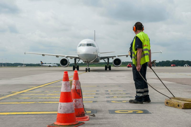 Bodencrew-Mitarbeiter steht auf dem Rollfeld des Flughafen Hamburg