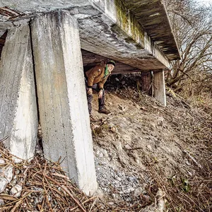 Blick in das Rattenloch, hinten lugt eine aufgeschreckte Ratte hervor. Rechts ein Stromkabel, das der Obdachlose vermutlich angezapft hat.