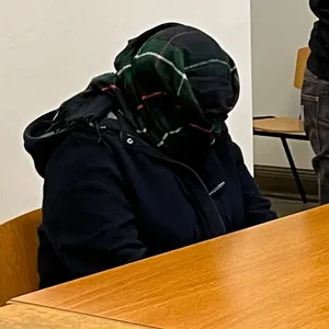 Die Angeklagte verbirgt ihr Gesicht hinter ihrem Schal.