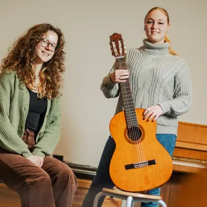 FSJlerinnen Mia Bloßfeld und Celina Heyden sitzen im Musikraum der Schule Bekkamp.