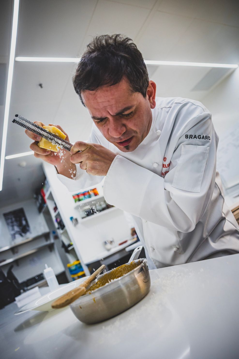 Matteo Ferrantino reibt Parmesan über die fertige Bolognese.