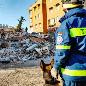 Ein Retter des THW steht vor einem zerstörten Haus im Erdbebengebiet der türkischen Provinz Hatay.