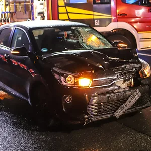 Beschädigtes Auto und Feuerwehr