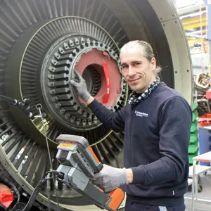 Mechaniker Philippe Puchalka untersucht das Triebwerk eines Flugzeugs mit einer kleinen Kamera.
