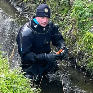 Ein Polizist sucht die Umgebung eines Campingplatzes bei Westerland nach Spuren ab.