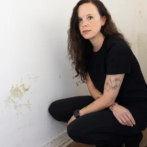 Julie Bohnhoff zeigt Schimmel, der sich im Kinderzimmer an der Wand gebildet hat.