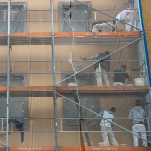 Arbeiter verrichten Arbeiten an der Fassade eines Hauses. .