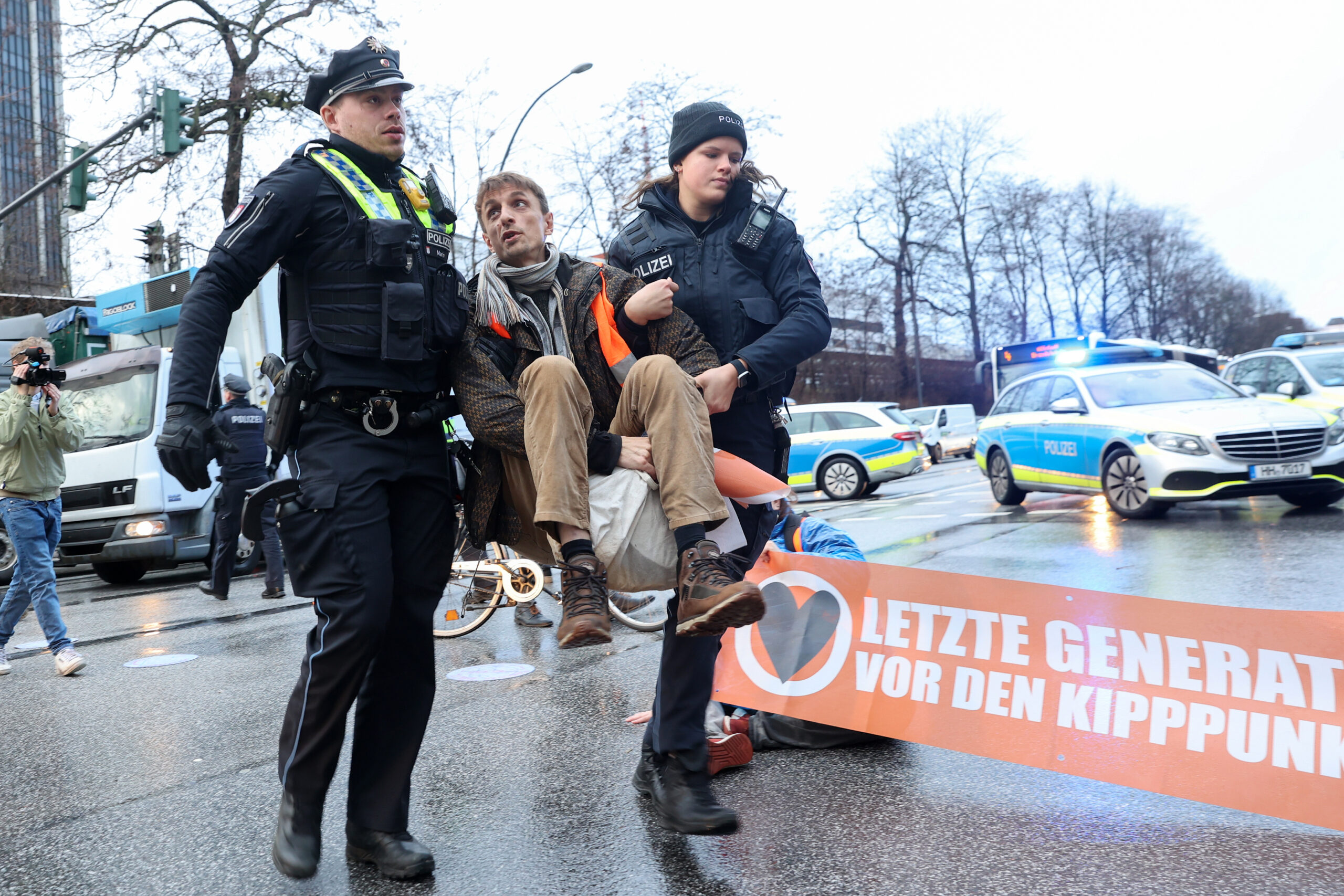Polizisten tragen einen Aktivisten von der Straße, der nicht festgeklebt war.