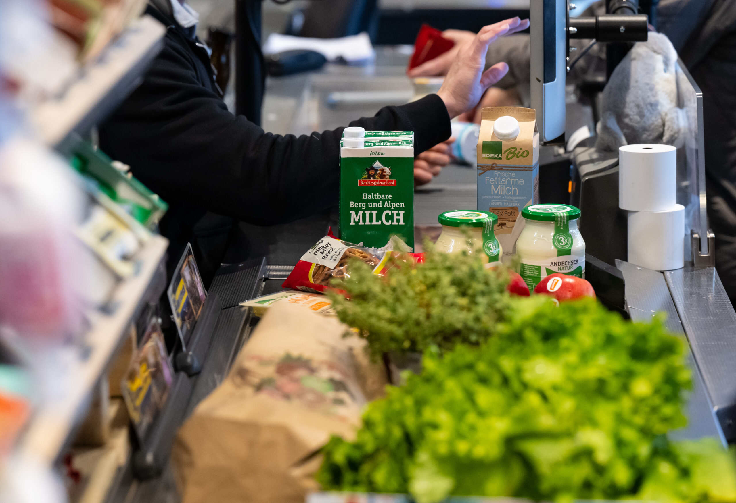 Symbolbild: Lebensmittel liegen in einem Supermarkt an der Kasse auf dem Band.