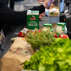 Symbolbild: Lebensmittel liegen in einem Supermarkt an der Kasse auf dem Band.