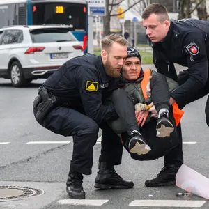 Polizisten tragen Klimaaktivisten weg