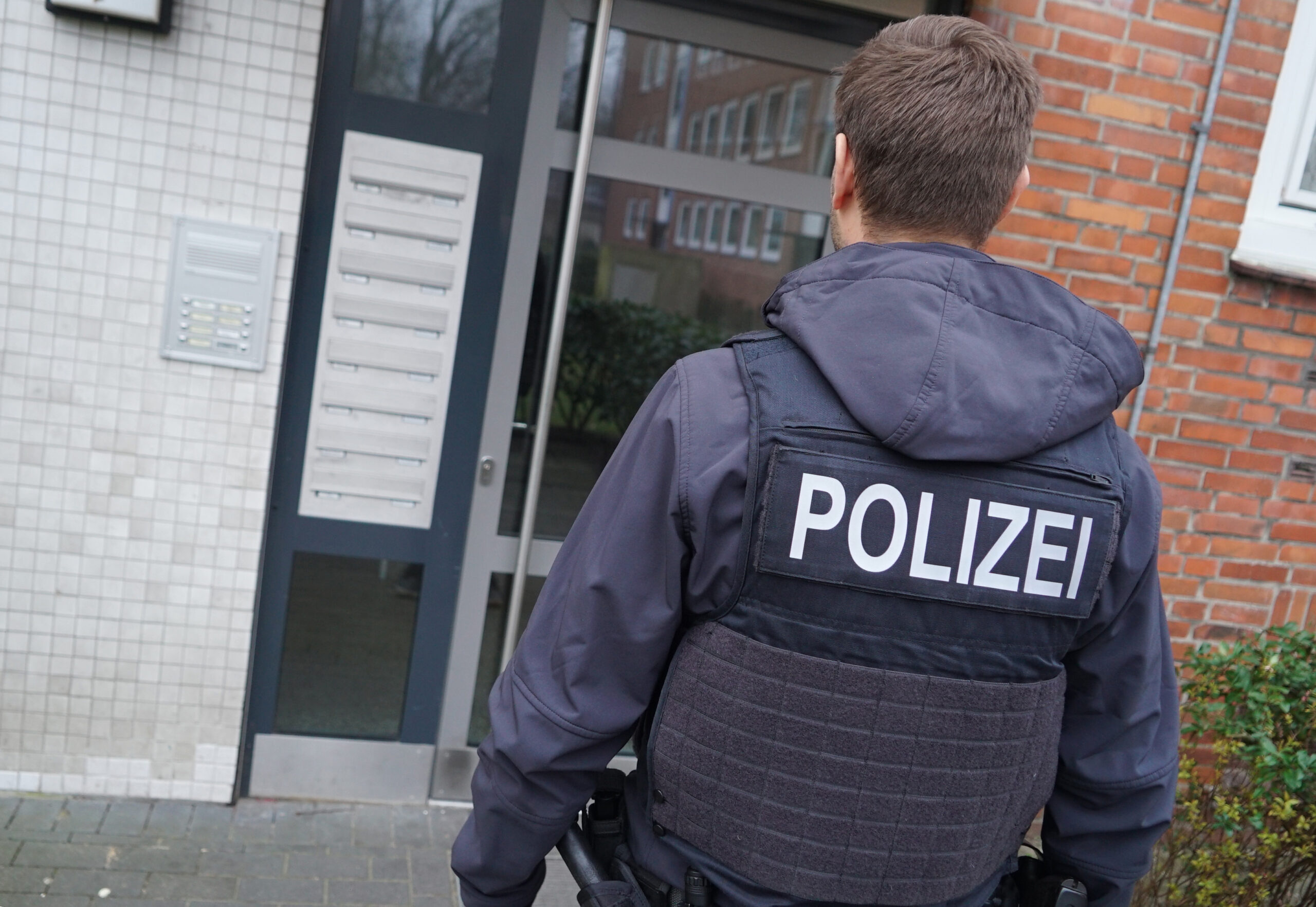 Ein Bundespolizist vor einem Hamburger Wohnhaus