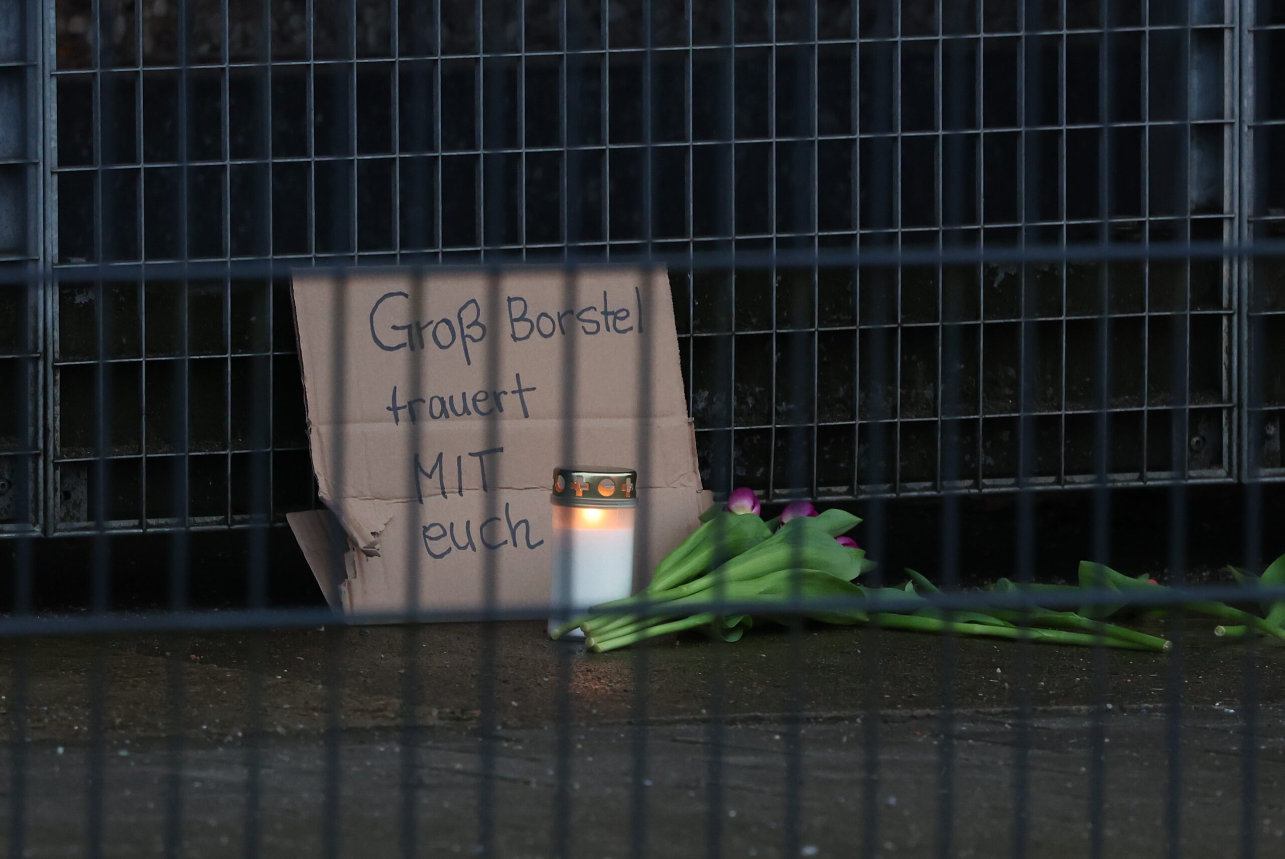 Blumen und eine beschriftete Pappe liegen vor dem Gebäude der Zeugen Jehovas im Stadtteil Alsterdorf.