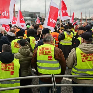 Mitarbeiterinnen und Mitarbeiter verschiedener Firmen am Airport Hamburg kommen auf einem Parkdeck am Flughafen zu einer Verdi-Kundgebung während ihres Warnstreiks zusammen.