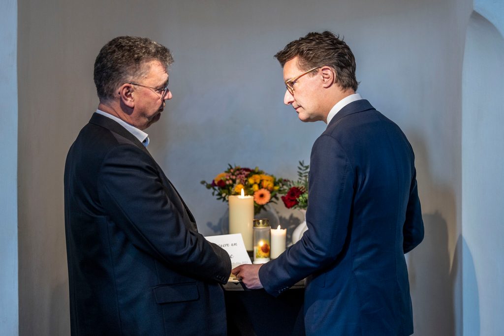 Hendrik Wüst (r, CDU), Ministerpräsident von Nordrhein-Westfalen, spricht Pfarrer Thomas Ijewski, bevor sich der Ministerpräsident in das Kondolenzbuch einträgt.