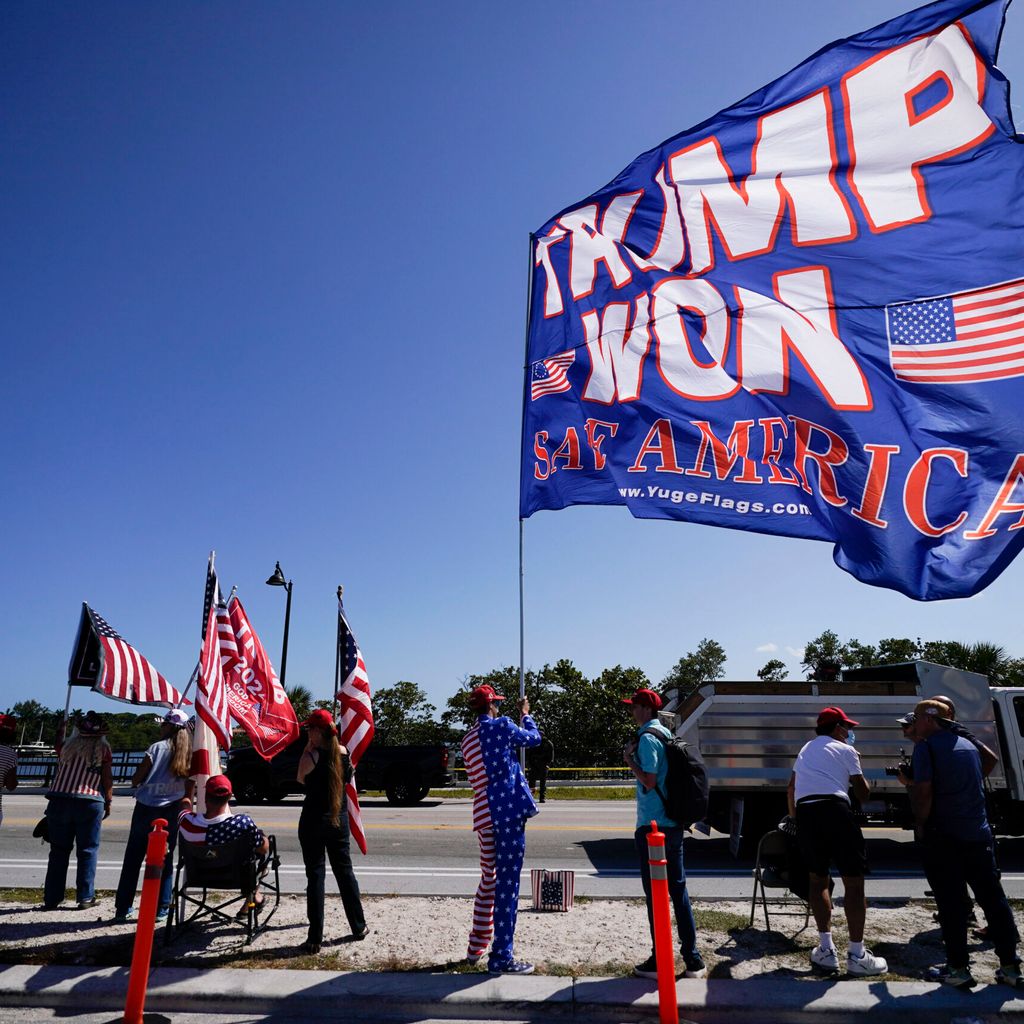 Anhänger des ehemaligen US-Präsidenten Trump hissen Fahnen vor seinem Anwesen Mar-a-Lago in West Palm Beach, Florida.