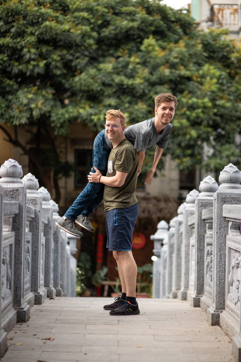 Lovis Wiefelschütz (unten) trägt seinen Freund Alexander Källner (oben) über der Schulter auf einer Brücke in Vietnam.