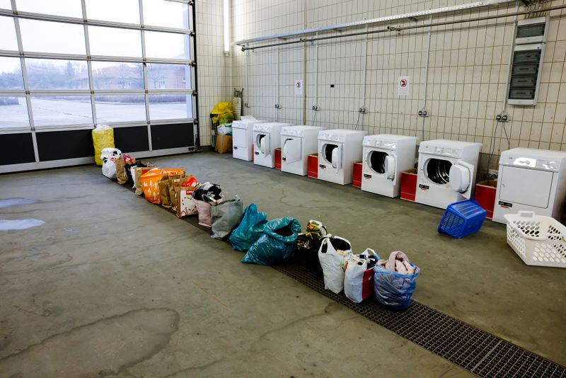 Waschmaschinen und Tüten mit Kleidungsstücken stehen in einem Waschraum der Landesunterkunft der Gemeinde Seeth