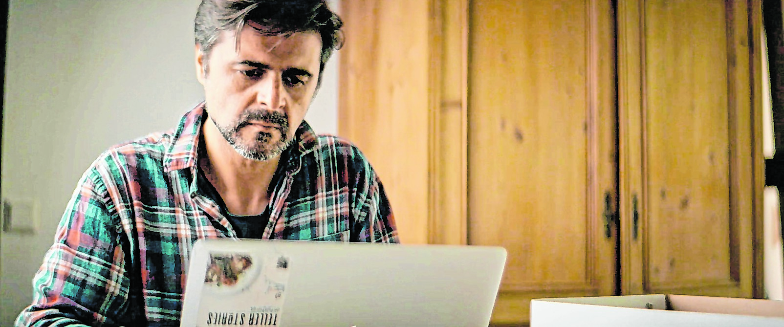 Szene aus der Doku, Moreno sitzt an seinem Laptop und schaut auf den Bildschirm