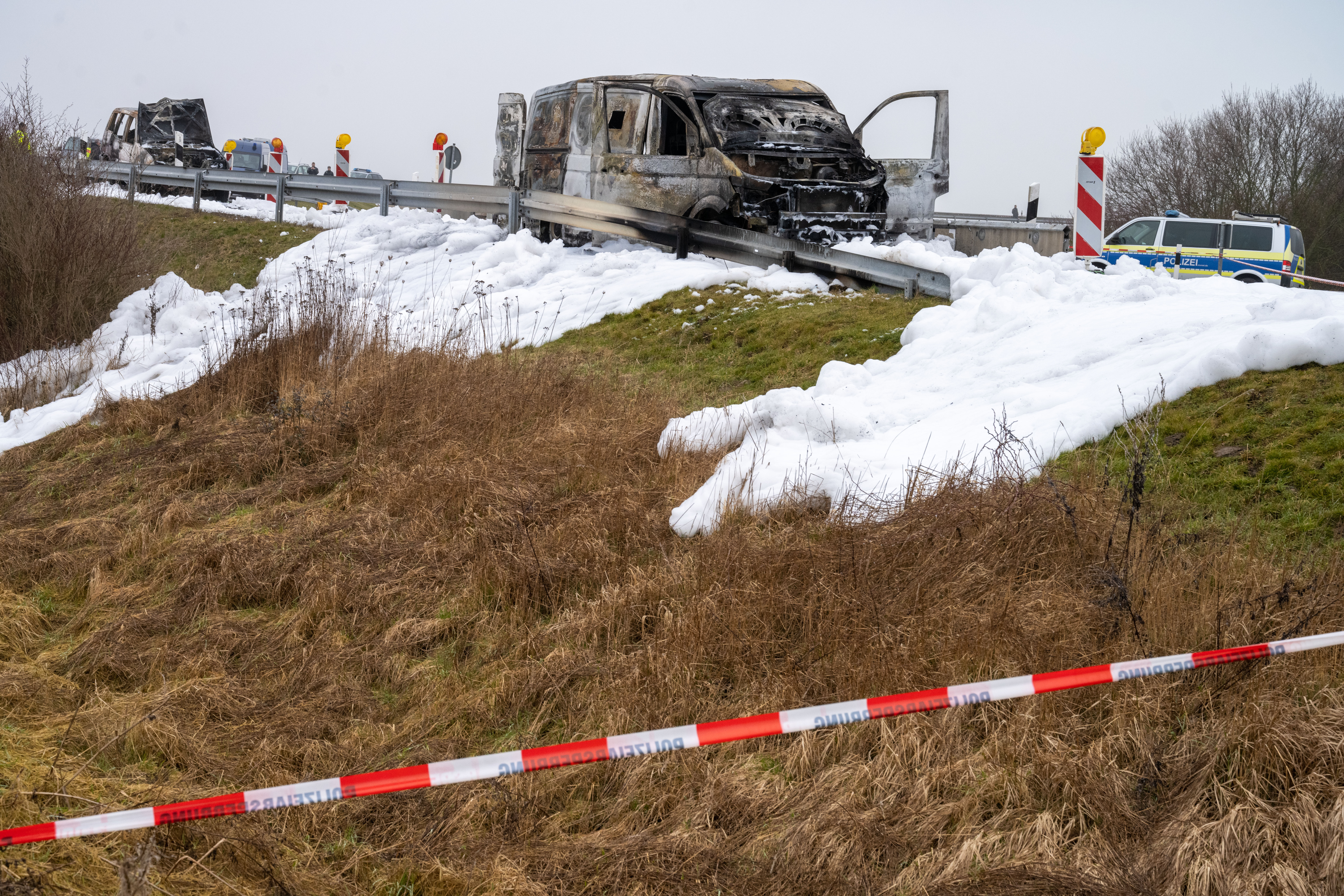 Nach dem Überfall setzten die Räuber den Geldtransporter und eines ihrer eigenen Fahrzeuge (im Foto links) in Brand.