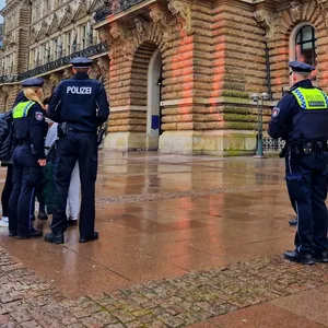Aktivisten der „Letzten Generation“ haben das Eingangsportal des Hamburger Rathauses mit oranger Farbe besprüht.