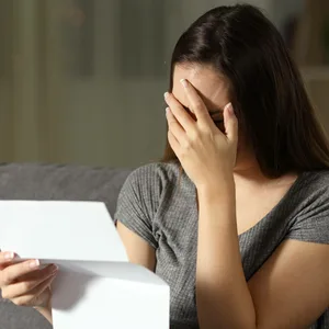 Für viele Mieter:innen sind es wirtschaftlich schwierige Zeiten. (Symbolbild: Frau hält ein Schreiben in der Hand)