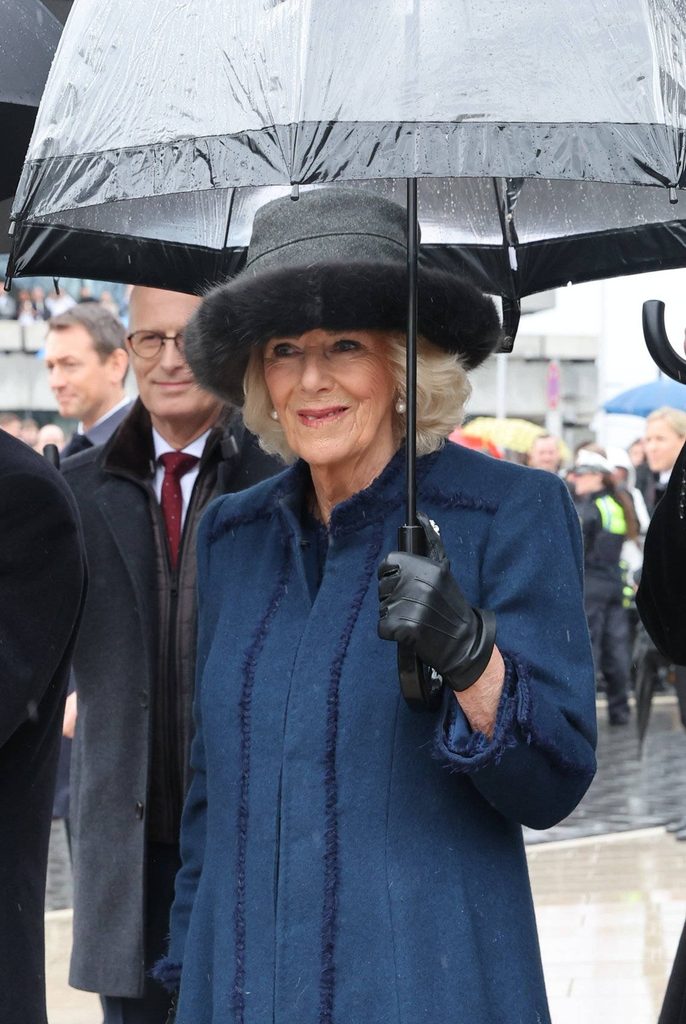 Camilla mit einem Regenschirm beim Bahnhof Dammtor