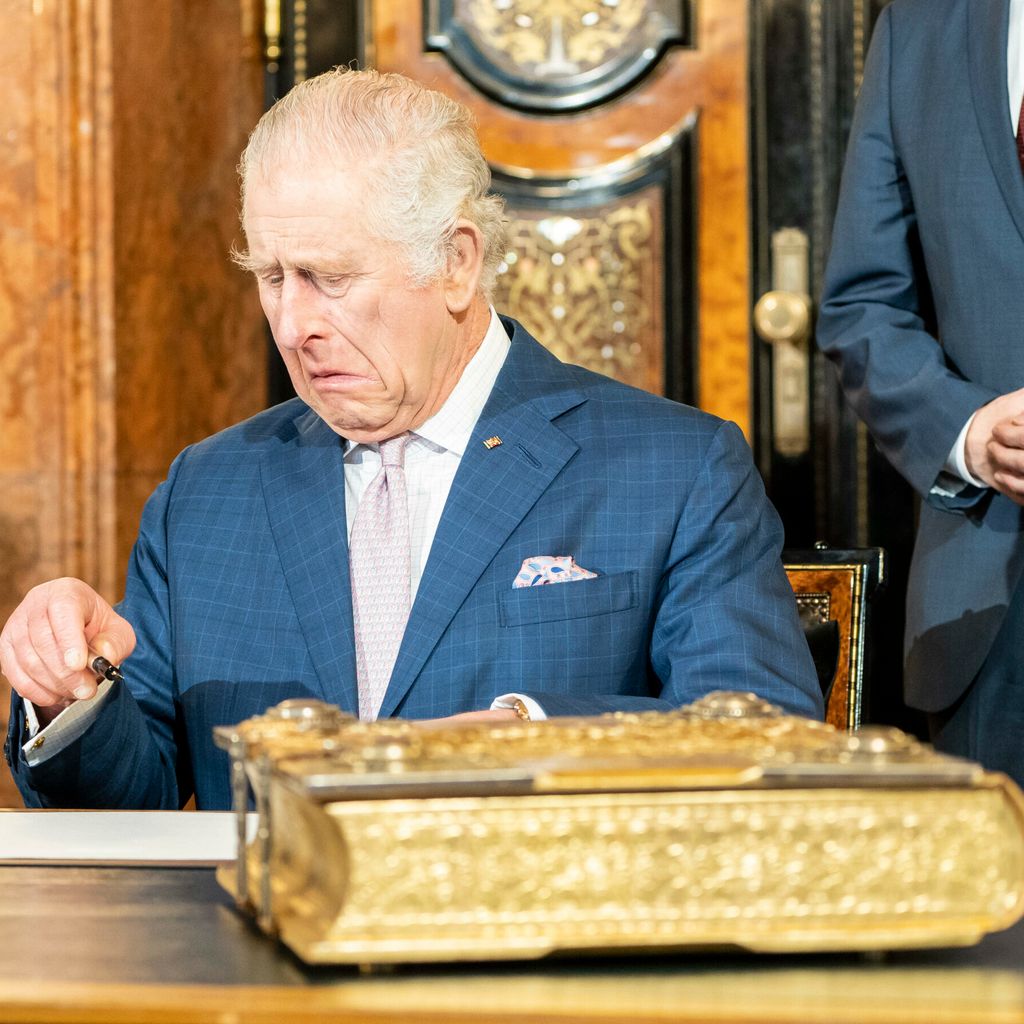 König Charles beim Unterschreiben