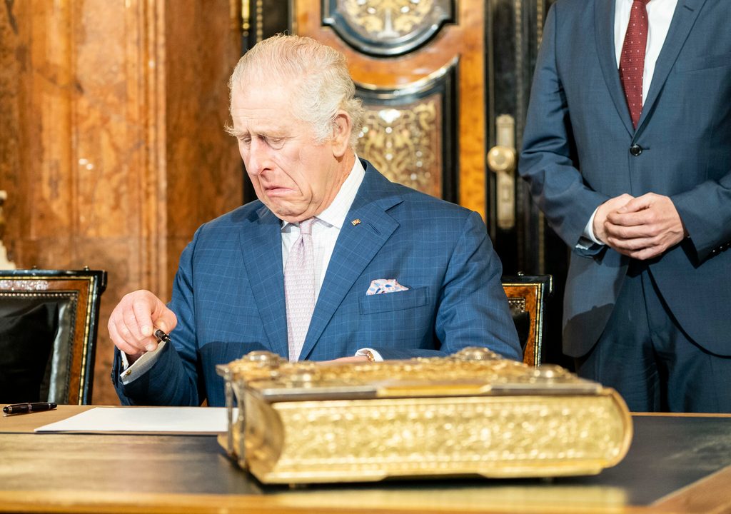 König Charles beim Unterschreiben