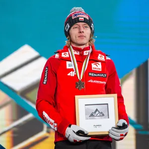 Skispringer Dawid Kubacki während einer Siegerehrung auf dem Podest