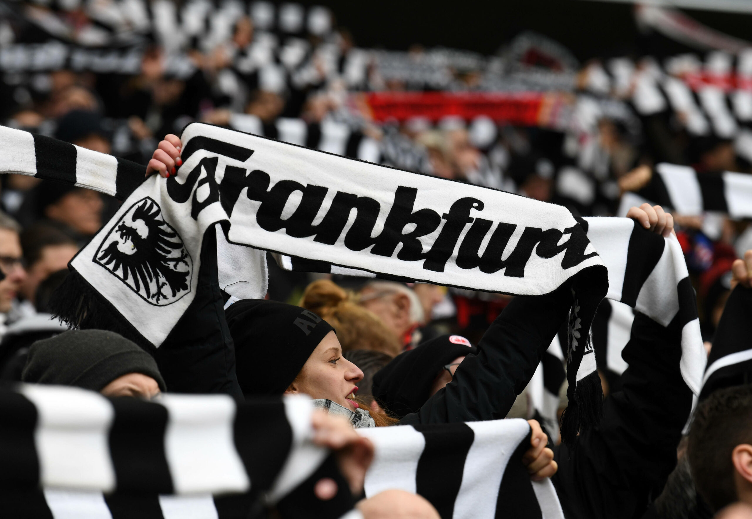 Frankfurt-Fans halten ihre Schals hoch.