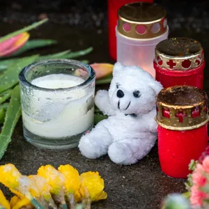 Grablichter, Blumen und Teddybären