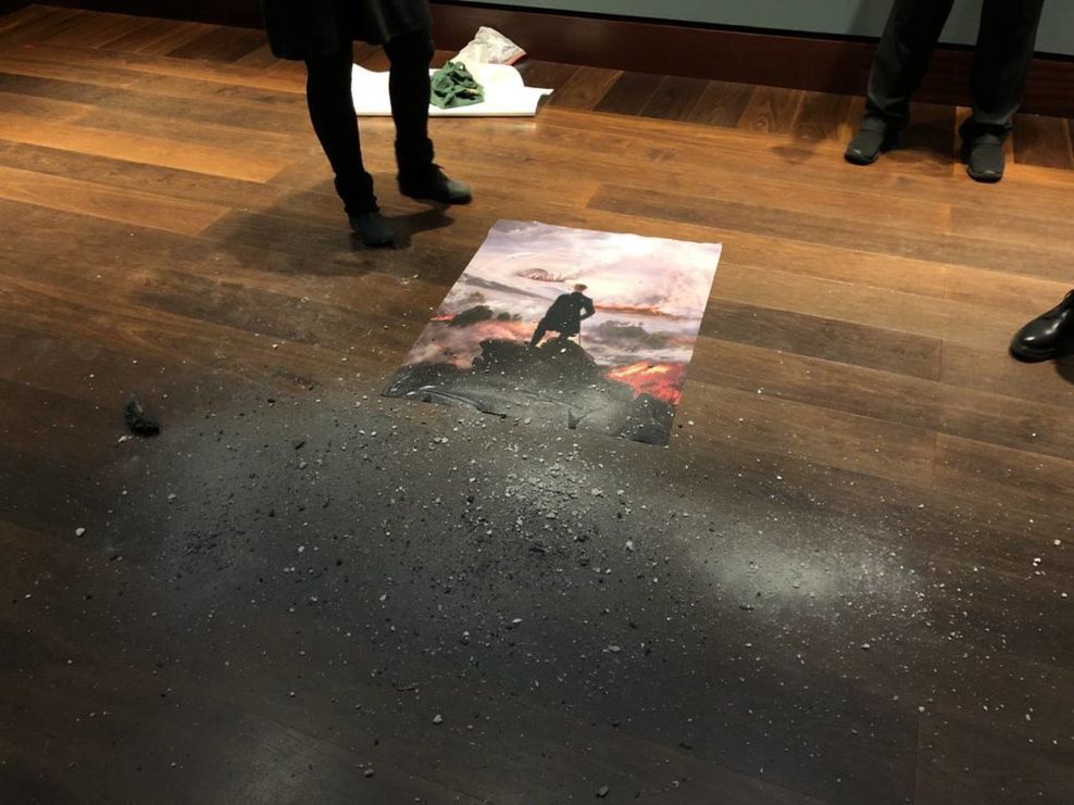 Die beiden Frauen haben ihre mitgebrachte Version des Bildes auf den Boden gelegt und mit Asche bestreut.