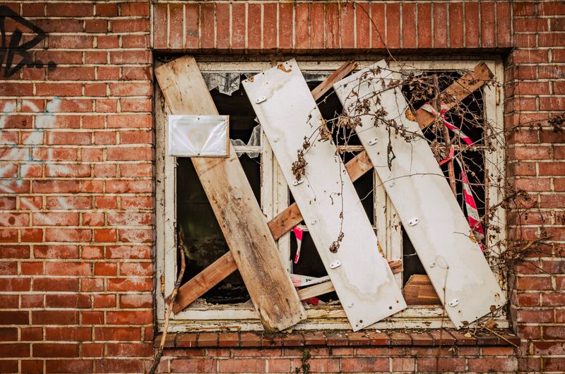 Die Fenster sind nur notdürftig mit Brettern vernagelt.