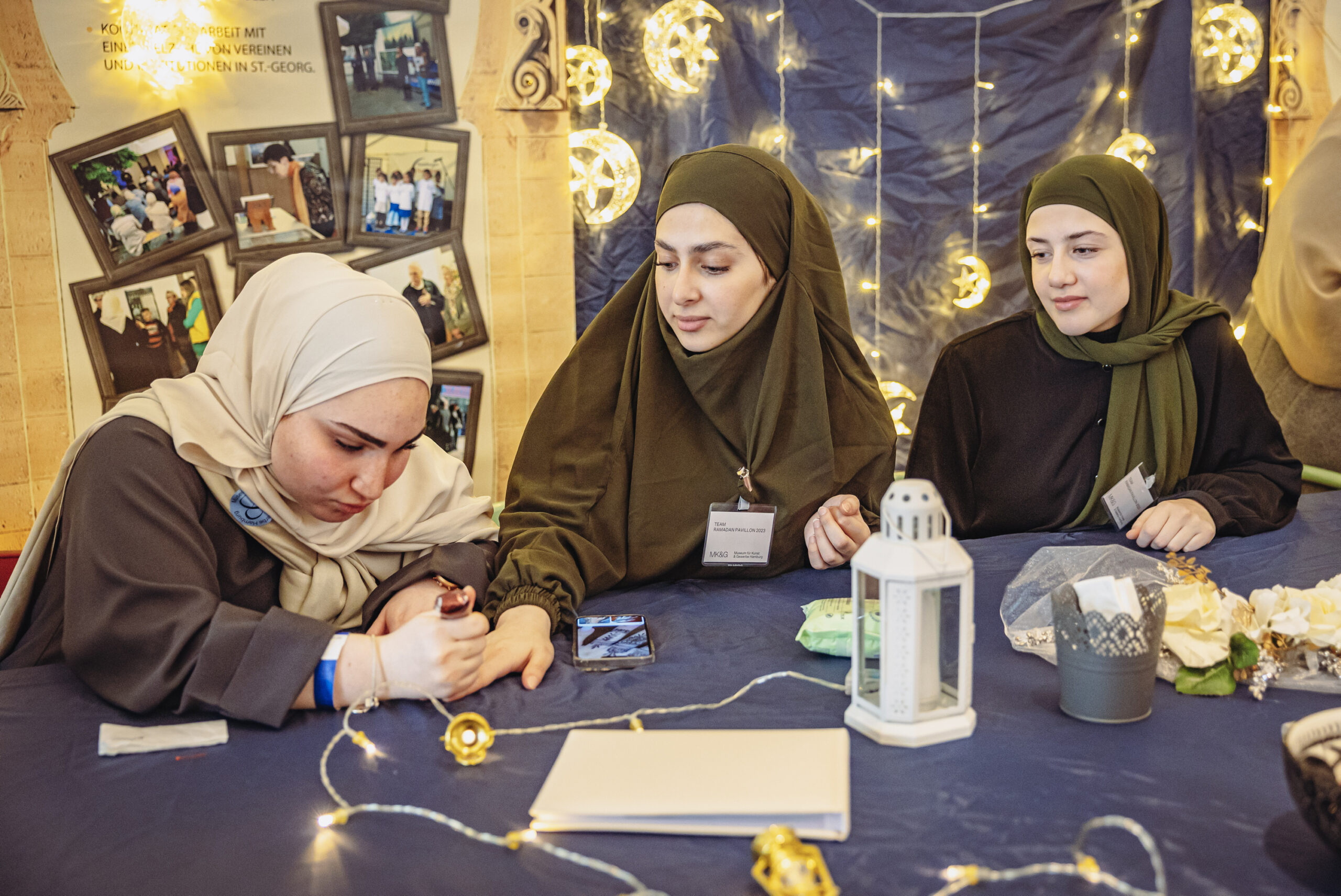 Die Mädchen vom Jugendtreff malen sich gegenseitig Henna auf die Hände. Außerdem bieten sie Hijab-Anproben und Poetry Slam an.