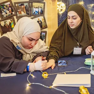 Die Mädchen vom Jugendtreff malen sich gegenseitig Henna auf die Hände. Außerdem bieten sie Hijab-Anproben und Poetry Slam an.