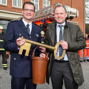 Christian Schwarz und Andy Grote 2018 bei der Amtseinführung. Sie halten einen großen goldenen Schlüssel und einen Eimer in den Händen und lächeln.
