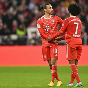 Leroy Sané und Serge Gnabry klatschen ab.