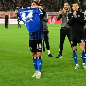 Ludovit Reis hält in Düsseldorf ein Trikot von Mario Vuskovic hoch