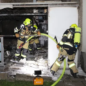 Feuerwehrleute löschen das Feuer in dem Verschlag.