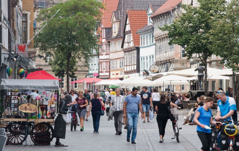 Passanten gehen durch die Innenstadt von Hameln, eine der klassischen Fachwerk-Altstädte in Niedersachsen.