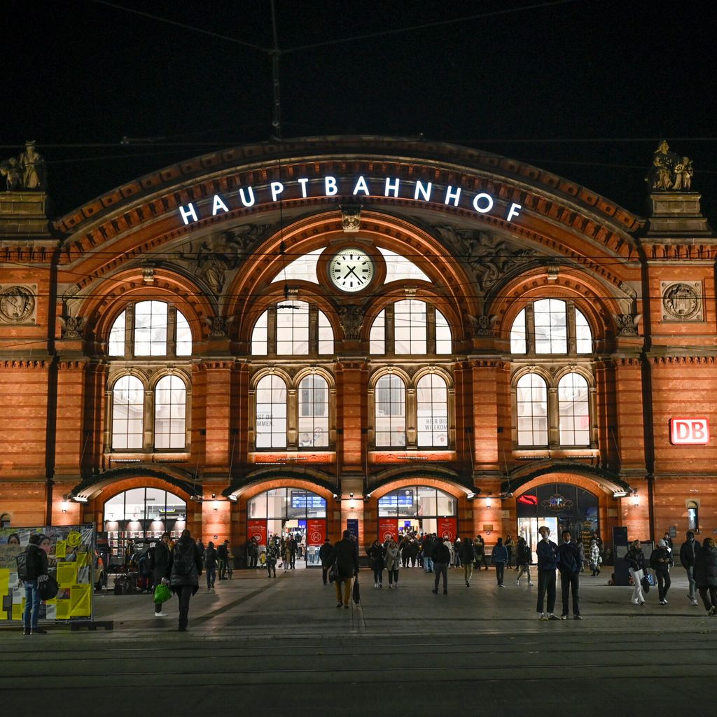 Menschen stehen am Abend vor dem Hauptbahnhof.