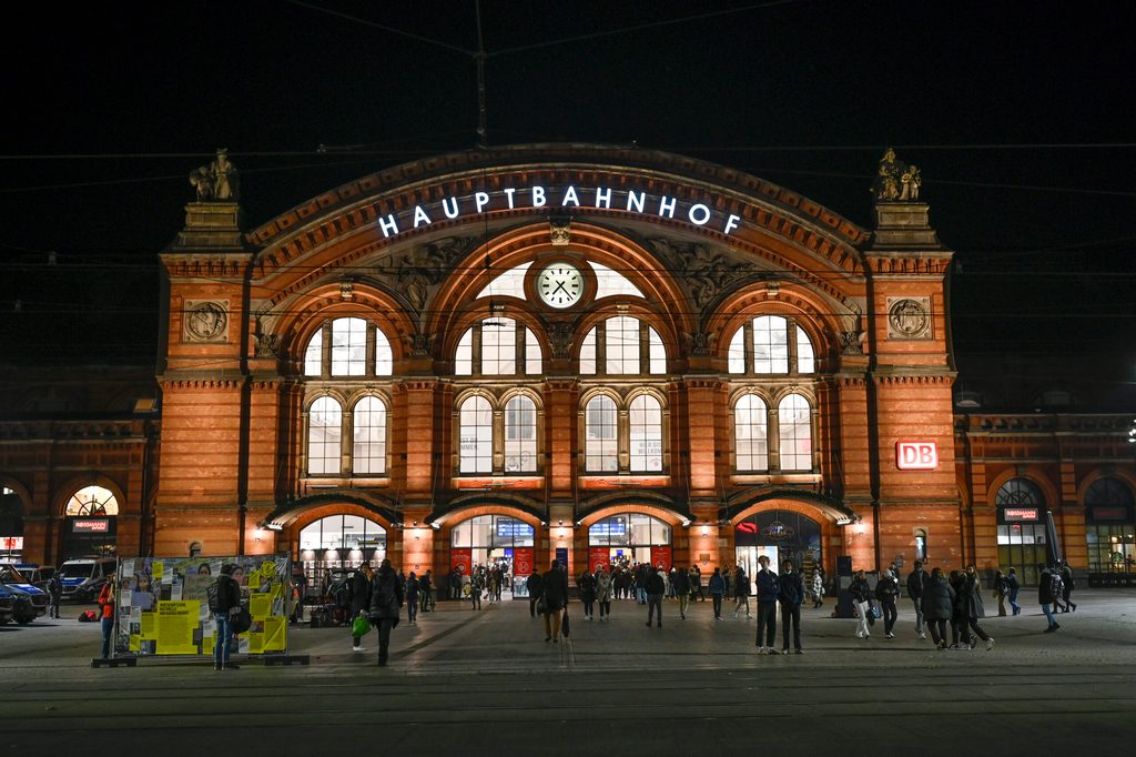 Menschen stehen am Abend vor dem Hauptbahnhof.