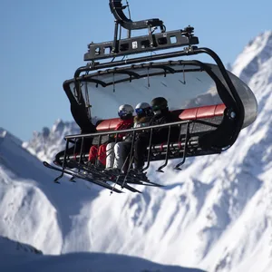Skifahrer fahren im Sessellift in Skigebiet (Symbolbild).
