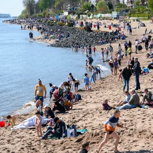 Zahlreiche Menschen genießen am Elbstrand in Övelgönne das warme Wetter.