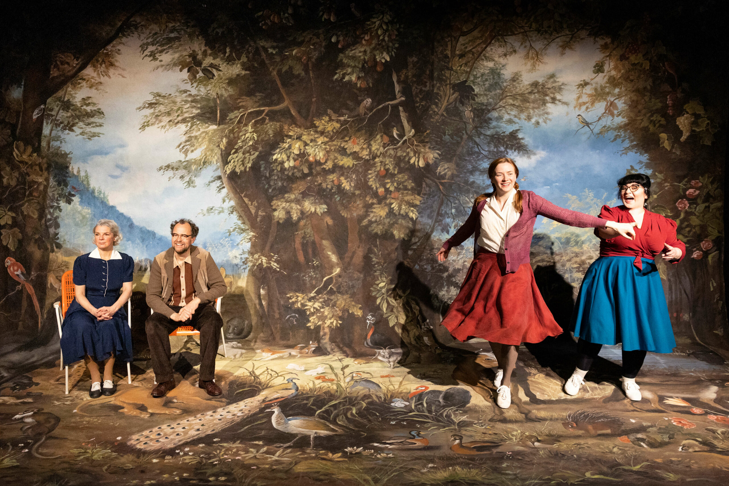 Drei Schauspielerinnen und ein Schauspieler vor einem prächtig bemalten Landschaftsbühnenbild