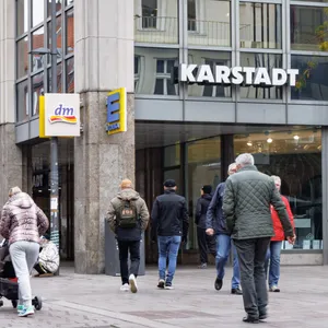 Passanten gehen auf der Breiten Strasse in der Innenstadt am Kaufhaus von Karstadt vorbei.