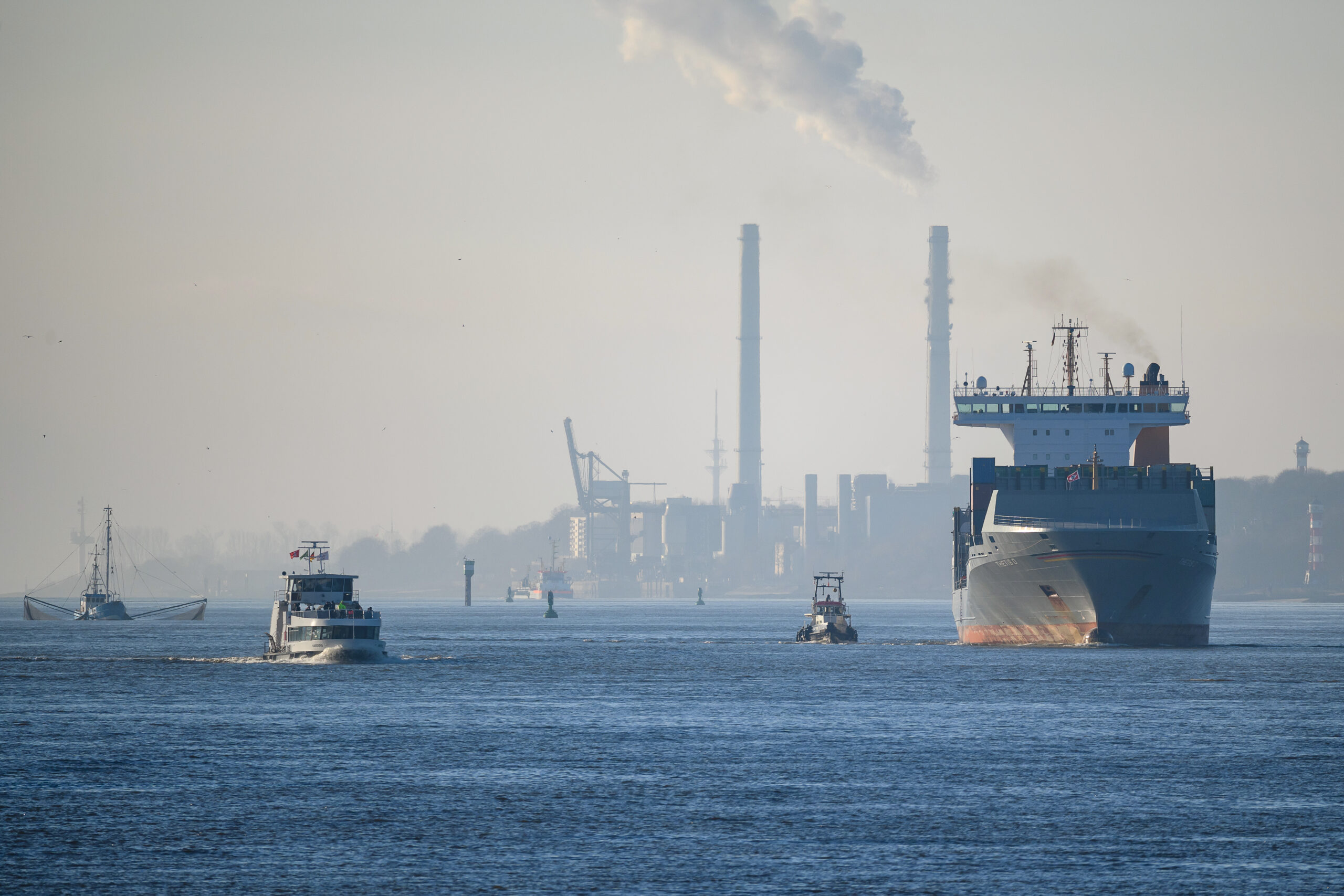 Mehrere Schiffe sind auf der Elbe vor dem Heizkraftwerk Wedel unterwegs.